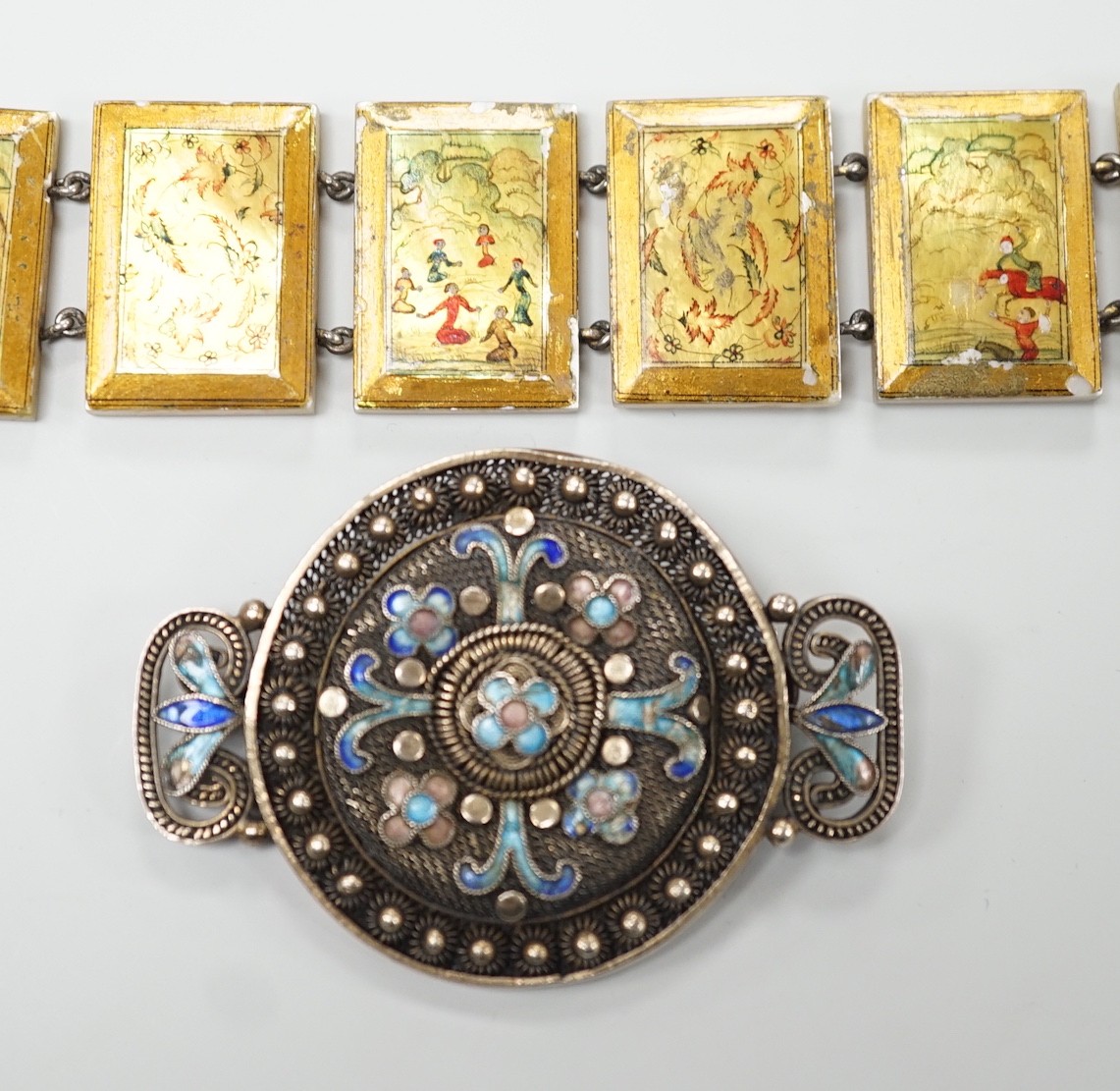 A Persian lacquered mother of pearl panel bracelet, 17cm and a Chinese filigree white metal and 'kingfisher' enamelled brooch, 54mm.
